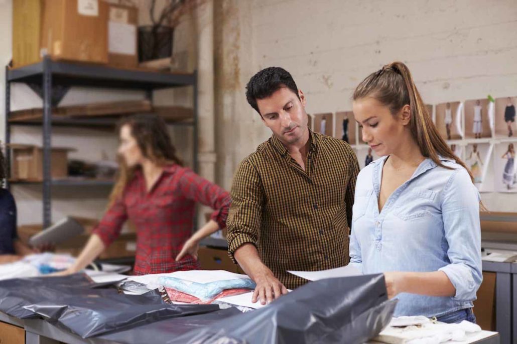 Distribution center workers packing clothing